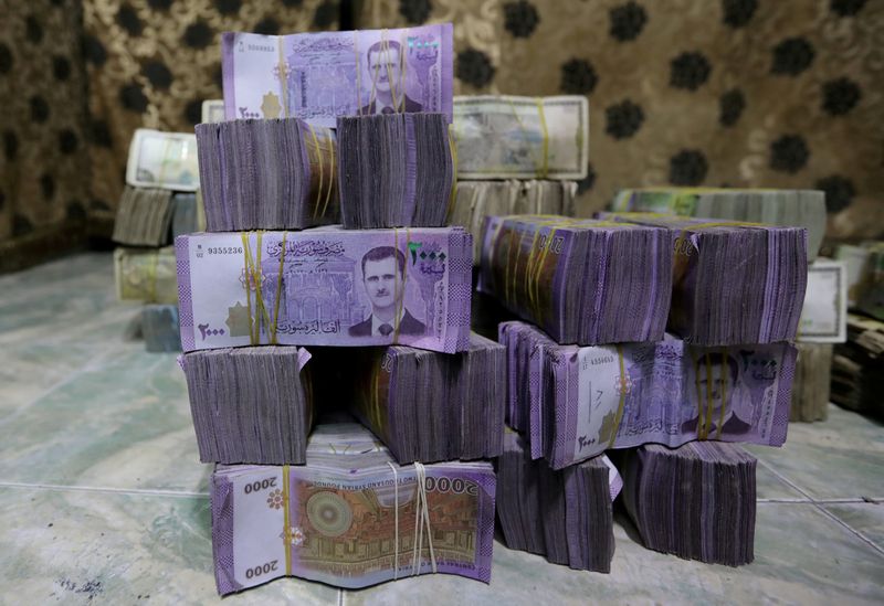 &copy; Reuters. FILE PHOTO: Stacks of Syrian pounds are pictured inside an exchange currency shop in Azaz, Syria February 3, 2020. Picture taken February 3, 2020. REUTERS/Khalil Ashawi