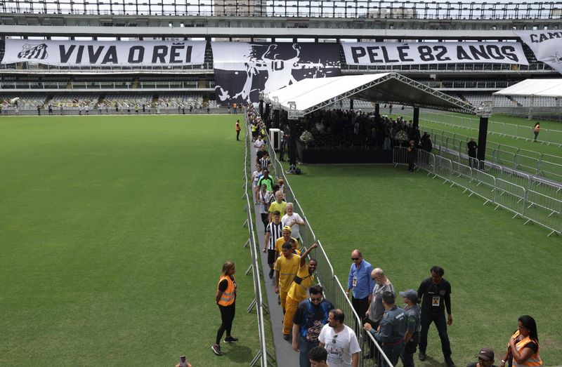 &copy; Reuters. أفراد ينتظرون إلقاء نظرة الوداع على جثمان أسطورة الكرة البرازيلي بيليه في فيلا بلميرو ملعب نادي سانتوس يوم الاثنين. تصوير: ريكاردو مواريس - 