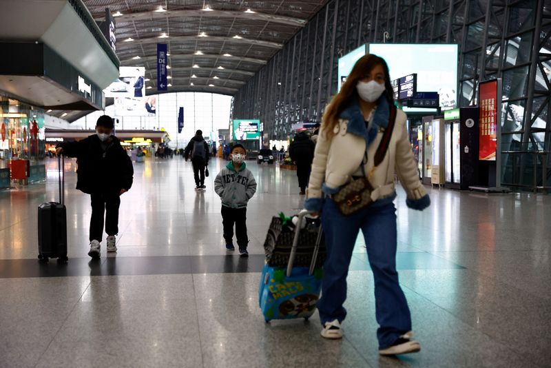 &copy; Reuters. Diversi viaggiatori con mascherine presso l'aeroporto internazionale Chengdu Shuangliu a Chengdu, nella provincia di Sichuan, in Cina. REUTERS/Tingshu Wang
