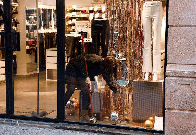 © Reuters. A saleswoman cleans the display of a clothing store in Ronda, southern Spain, January 3, 2023. REUTERS/Jon Nazca