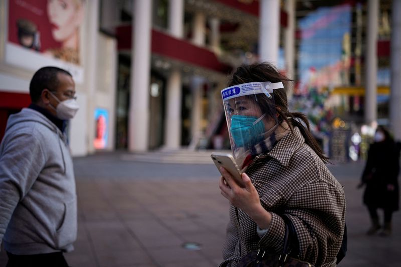 &copy; Reuters. Une femme portant un masque de protection et un écran facial marche à Shanghai, en Chine. /Photo prise le 3 janvier 2023/REUTERS/Aly Song