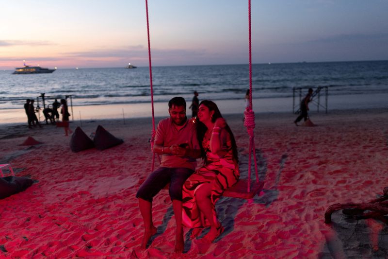 &copy; Reuters. Un couple est assis sur une balançoire au crépuscule sur une plage de Phuket, en Thaïlande. /Photo prise le 28 décembre 2022/REUTERS/Jorge Sil