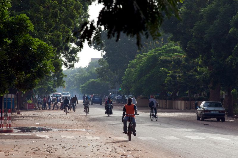 &copy; Reuters. Des personnes se déplacent à vélo et à moto dans une rue de Ouagadougou, au Burkina Faso. /Photo prise le 17 septembre 2015/REUTERS/Joe Penney