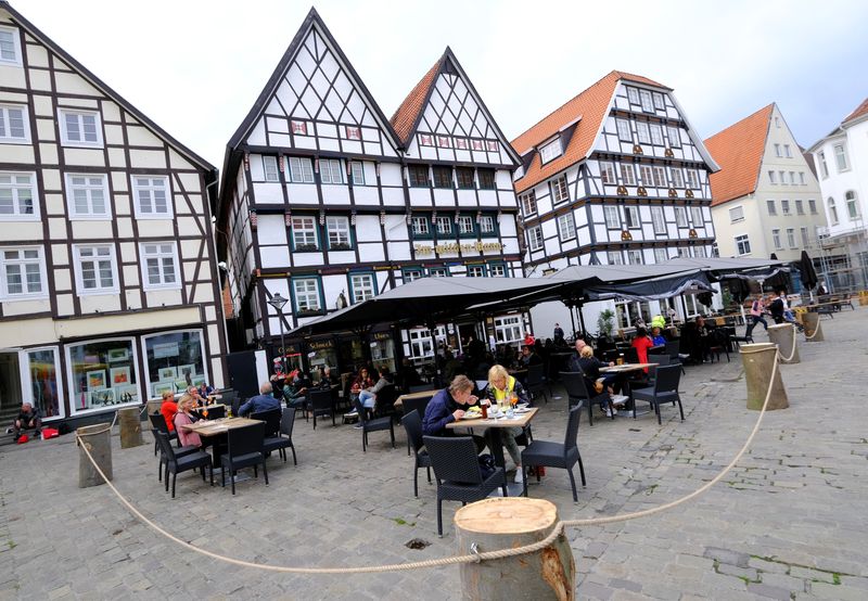 &copy; Reuters. FILE PHOTO: People eat outdoors in a cordoned-off area of a restaurant on the historic main market square of Soest, Germany, May 12, 2021, as the North-Rhine Westphalian town eased their lock-down policy during the spread of the COVID-19 pandemic.    REUT