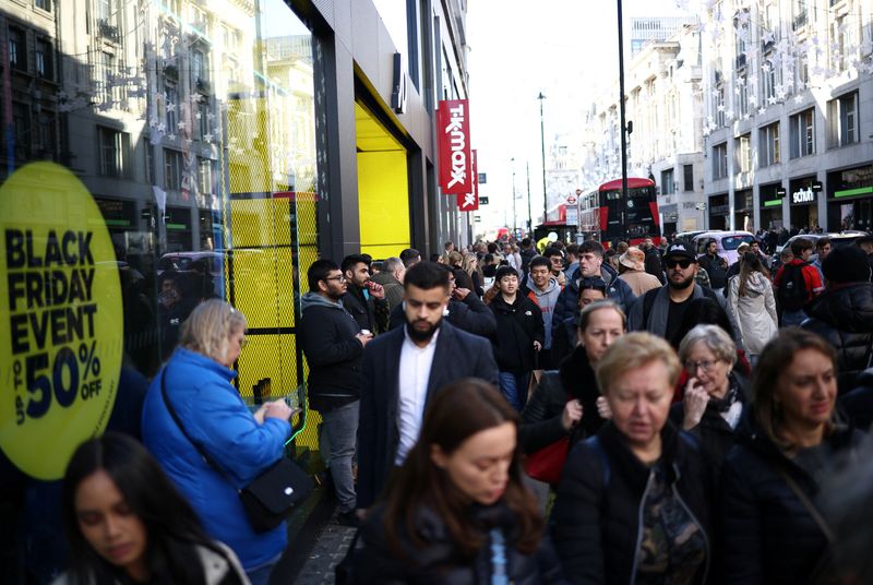 &copy; Reuters. Des personnes passent devant les affiches du Black Friday dans les vitrines des magasins pendant le Black Friday sur Oxford Street à Londres, Royaume-Uni/REUTERS/Henry Nicholls