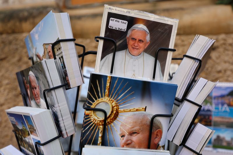 &copy; Reuters. A picture of former Pope Benedict is displayed outside St. Peter's Basilica, while faithful pay homage to former Pope Benedict as his body lies in state at the Basilica, at the Vatican January 4, 2023. REUTERS/Kai Pfaffenbach