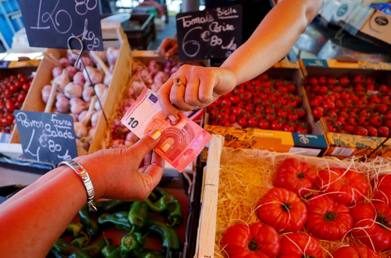 &copy; Reuters. مشتري يعطي البائع ورقة نقدية من فئة اليورو في مدينة نيس بفرنسا بتاريخ السابع من يونيو حزيران 2022. تصوير: إريك جيلارد - رويترز.