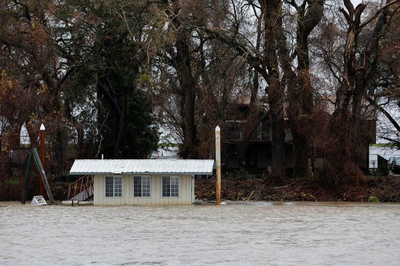 © Reuters. A partially submerged boathouse is seen on the Sacramento River, which level has risen due to storms, in West Sacramento, California, U.S. January 4, 2023. REUTERS/Fred Greaves