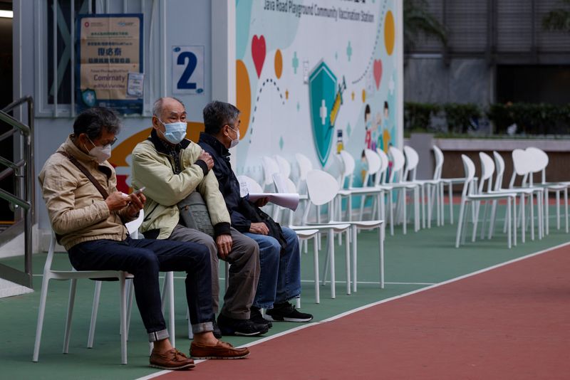 &copy; Reuters. أشخاص يجلسون في مركز تطعيم مجتمعي  في هونج كونج يوم الأربعاء. تصوير: تايرون سيو - رويترز.