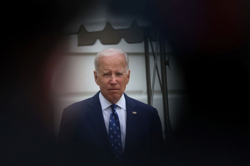 &copy; Reuters. FILE PHOTO: U.S. President Joe Biden, as seen through the gap between a videographer and his camera, walks towards the news media before boarding Marine One for travel to Kentucky from the South Lawn of the White House, in Washington, U.S., January 4, 202