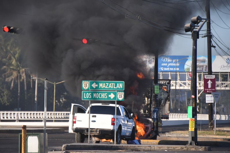 © Reuters. Burning vehicles are seen blocking a road after drug lord Ovidio Guzman's capture, in Culiacan, Sinaloa, Mexico January 5, 2023. Revista Espejo/Leo Espinoza/Handout via REUTERS   