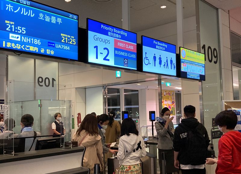 &copy; Reuters. FILE PHOTO-Travelers line up to board a Hawaii-bound flight from Tokyo's Haneda International Airport during Japan's "Golden Week" holidays, in Tokyo, Japan April 29, 2022. Picture taken April 29, 2022. REUTERS/Maki Shiraki