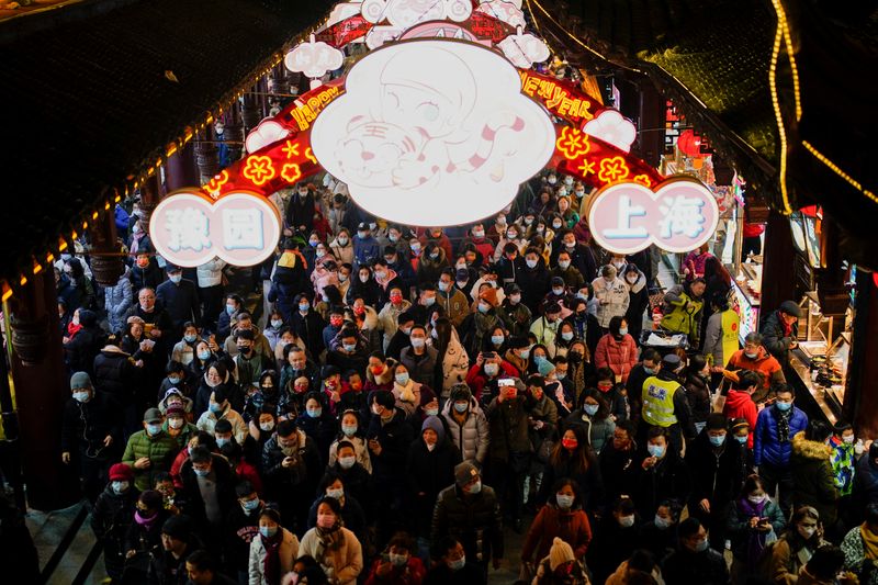 &copy; Reuters. FILE PHOTO: People wearing protective masks walk by an area decorated with lanterns during the Chinese Lunar New Year festivity at Yu Garden, following new coronavirus disease (COVID-19) cases in Shanghai, China February 1, 2022. REUTERS/Aly Song