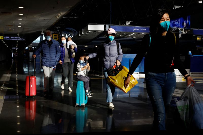 &copy; Reuters. مسافرون في مطار بكين الدولي يرتدون كمامات وسط انتشار فيروس كورونا في بكين بتاريخ 27 ديسمبر كانون الأول 2022. تصوير: تينغ شو وانغ - رويترز.