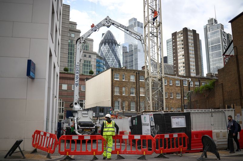 &copy; Reuters. FOTO DE ARCHIVO: Un trabajador de la construcción mueve barreras en una obra, con el distrito financiero de la City de Londres al fondo, en Londres, Reino Unido, 3 de octubre de 2022. REUTERS/Henry Nicholls