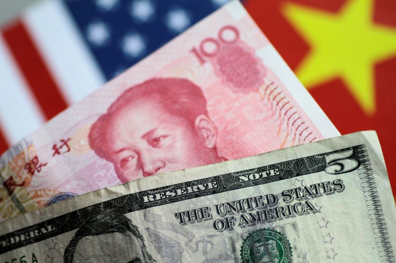 &copy; Reuters. ورقة مالية من الدولار الأمريكي وأخرى من اليوان الصيني في صورة من أرشيف رويترز.