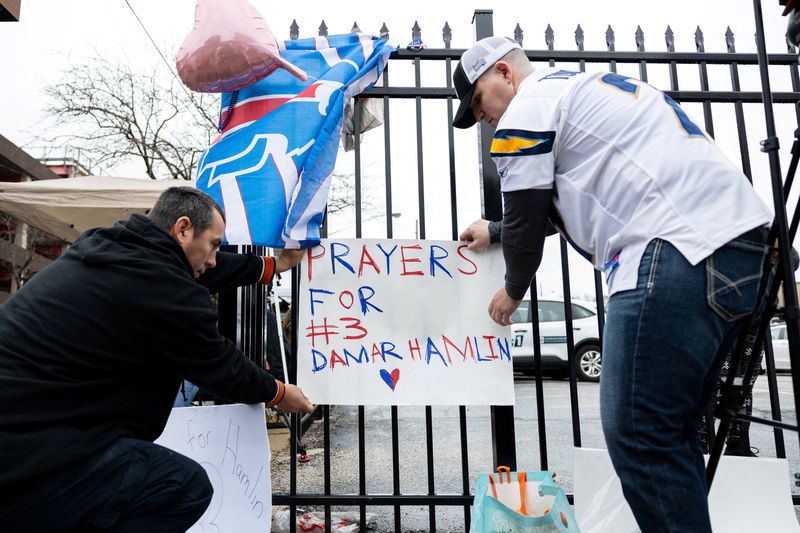 &copy; Reuters. FILE PHOTO: Football fans tape a sign to a fence during a vigil outside the University of Cincinnati Medical Center where Buffalo Bills safety Damar Hamlin lies in critical condition, after suffering a cardiac arrest during the January 2 National Football
