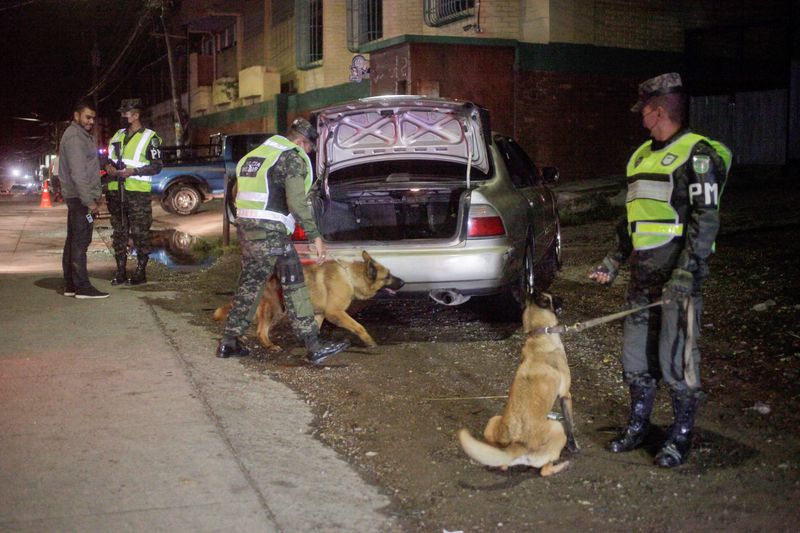 &copy; Reuters. FOTO DE ARCHIVO: Un oficial de la Policía Militar de Honduras utiliza un perro rastreador durante una inspección de vehículos en un puesto de control, como parte de una operación para frenar la delincuencia, en Tegucigalpa, Honduras 18 de julio 2022. 