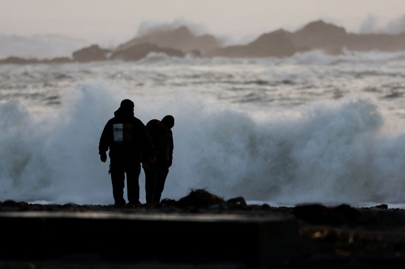 © Reuters. People look at items washed up on the beach from post-storm high surf at Van Damme Beach in Mendocino, California, U.S. January 5, 2023. REUTERS/Fred Greaves