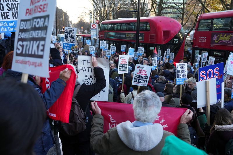 © Reuters. NHS nurses hold signs during a strike, amid a dispute with the government over pay, outside University College Hospital in London, Britain December 20, 2022. REUTERS/Maja Smiejkowska