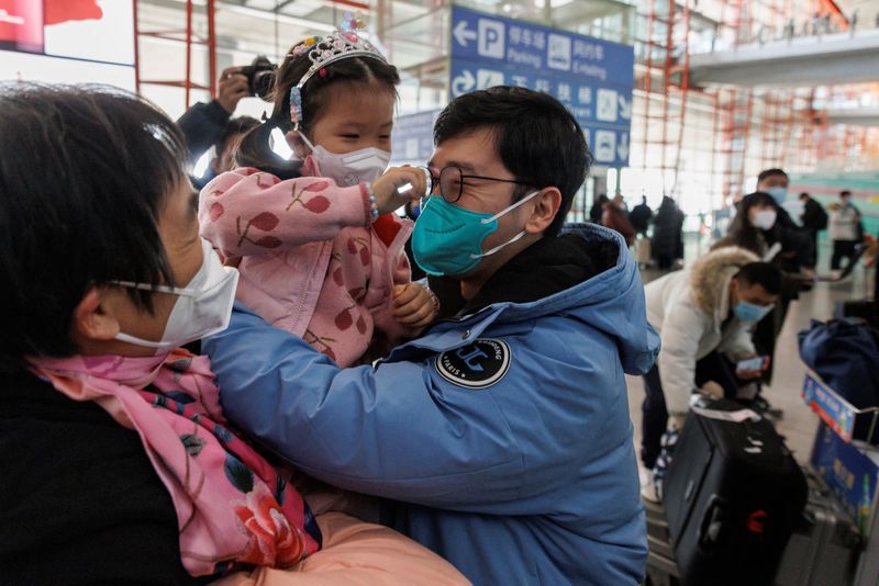 &copy; Reuters. Un grupo de personas se abraza en la puerta de llegadas internacionales del Aeropuerto Internacional de Pekín Capital después de que China levantó el requisito de cuarentena por la enfermedad del coronavirus (COVID-19) para los viajeros entrantes, en P