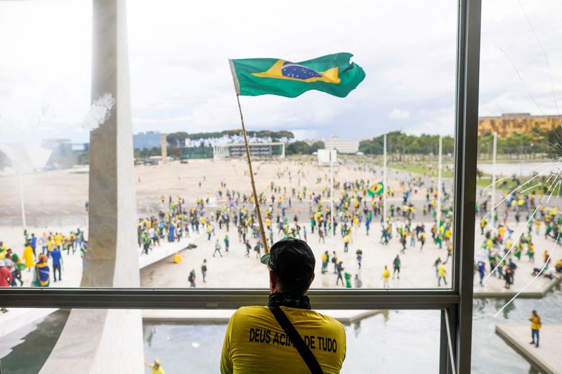 © Reuters. Um homem agita a bandeira do Brasil enquanto apoiadores do ex-presidente Jair Bolsonaro protestam contra o presidente Luiz Inácio Lula da Silva, do lado de fora do Congresso Nacional do Brasil em Brasília, Brasil, 8 de dezembro de 2023. REUTERS/Adriano Machado
