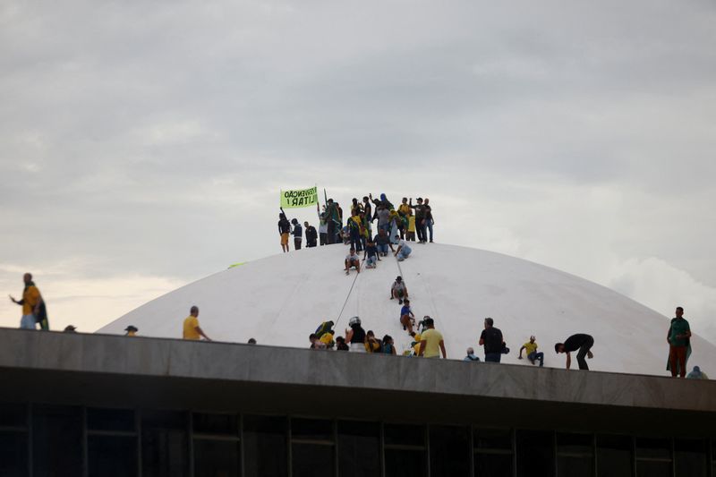 &copy; Reuters. Apoiadores do ex-presidente Jair Bolsonaro em cima do prédio do Congresso Nacional em Brasília após invadirem a sede do Legislativo
08/01/2023 REUTERS/Adriano Machado