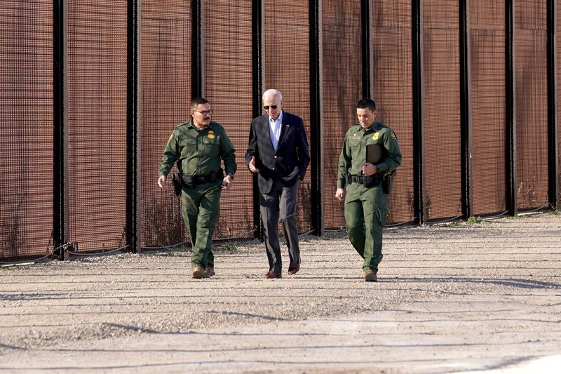 © Reuters. El presidente de Estados Unidos, Joe Biden, habla con agentes de la patrulla fronteriza mientras camina a lo largo de la valla fronteriza durante su visita a la frontera entre Estados Unidos y México para evaluar las operaciones de control fronterizo, en El Paso, Texas, Estados Unidos. 8 de enero de 2023.  REUTERS/Kevin Lamarque
