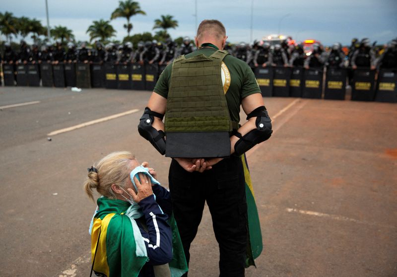 &copy; Reuters. Un partisan de l'ancien président brésilien d'extrême droite Jair Bolsonaro protège un autre partisan lors de manifestations, à Brasilia, au Brésil. /Photo prise le 8 janvier 2023/REUTERS/Antonio Cascio