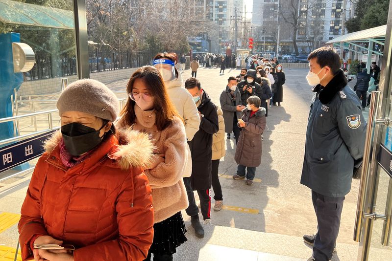 © Reuters. People line up at a government office for entry and exit matters which provides services including making or renewing passports or permits to go to Hong Kong, Macau and Taiwan, after China reopened borders, in Beijing, China January 9, 2023. REUTERS/Yew Lun Tian