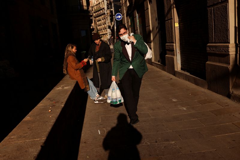&copy; Reuters. FILE PHOTO: A waiter wearing a face mask carries a bag with milk as he walks to the restaurant where he works, amid the coronavirus disease (COVID-19) pandemic in Barcelona, Spain February 1, 2022. REUTERS/Nacho Doce