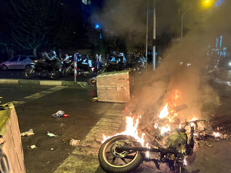 &copy; Reuters. دراجة نارية تابعة للشرطة تحترق خلال احتجاجات في طهران يوم 19 سبتمبر ايلول 2022. صورة من وكالة غرب اسيا للأنباء. 