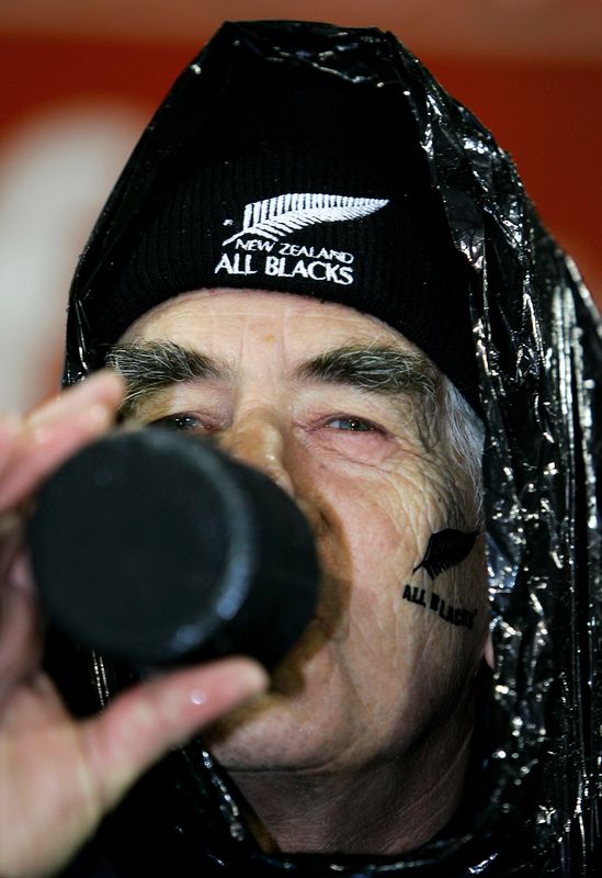&copy; Reuters. An All Black supporter drinks a beer as he sits in the rain before the first test against the British and Irish Lions at Jade Stadium in Christchurch June 25, 2005. REUTERS/David Gray