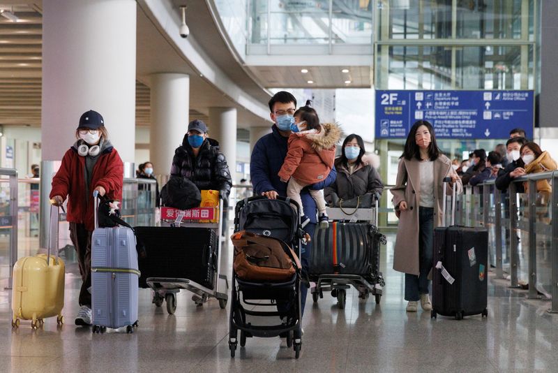 &copy; Reuters. FILE PHOTO: Passengers push their luggage through the international arrivals hall at Beijing Capital International Airport after China lifted the coronavirus disease (COVID-19) quarantine requirement for inbound travellers in Beijing, China January 8, 202