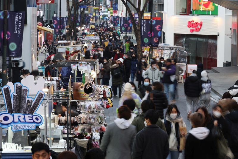 &copy; Reuters. Street vendors (L) wait for customers at Myeongdong shopping district in Seoul, South Korea, January 9, 2023.    REUTERS/Kim Hong-Ji