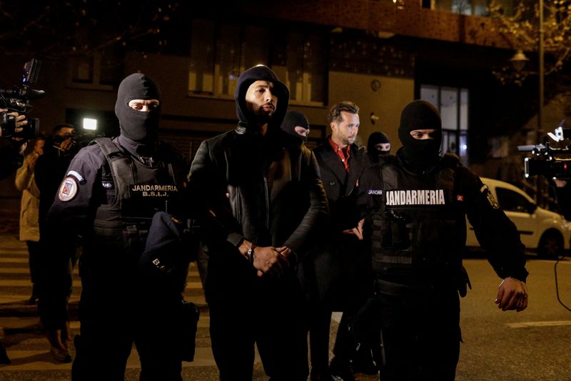 &copy; Reuters. FILE PHOTO: Andrew Tate and Tristan Tate are escorted by police officers outside the headquarters of the Directorate for Investigating Organized Crime and Terrorism in Bucharest (DIICOT) after being detained for 24 hours, in Bucharest, Romania, December 