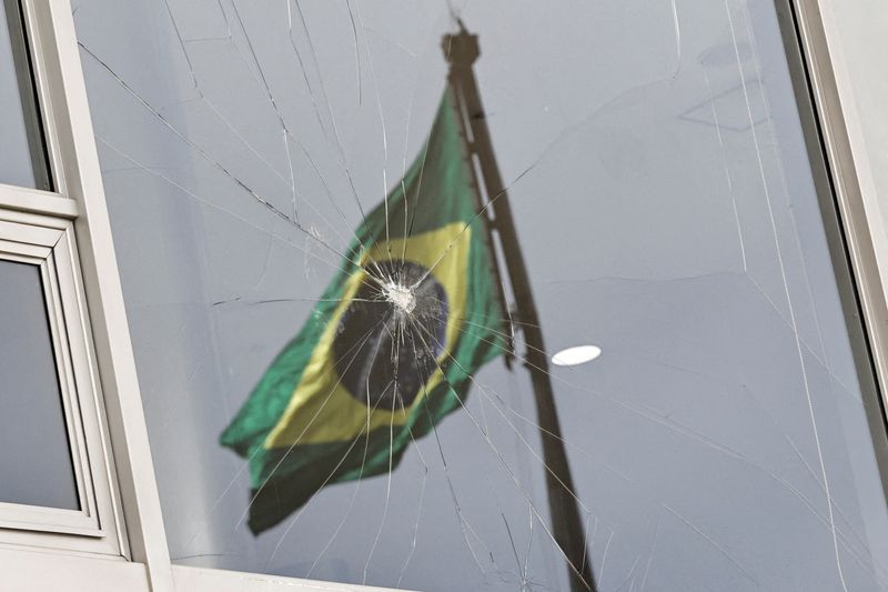 &copy; Reuters. Brazil's flag is reflected on a broken window, after the supporters of Brazil's former President Jair Bolsonaro participated in an anti-democratic riot at Planalto Palace, in Brasilia, Brazil, January 9, 2023. REUTERS/Ueslei Marcelino 