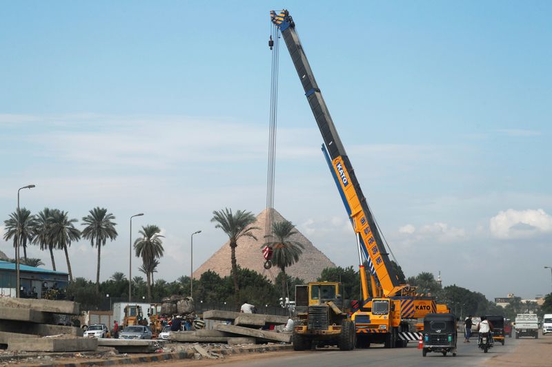 &copy; Reuters. Egyptian labourers work at a construction site of a new road as the pyramid of Khufu or "Cheops" is seen in the back, in Giza, Egypt, November 9, 2020. REUTERS/Amr Abdallah Dalsh/Files