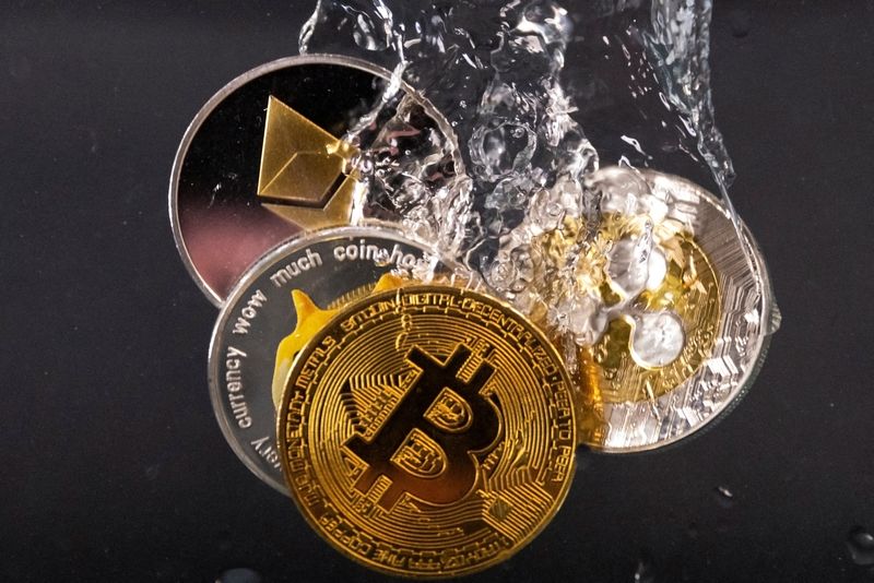 © Reuters. FILE PHOTO: Souvenir tokens representing cryptocurrency networks Bitcoin, Ethereum, Dogecoin and Ripple plunge into water in this illustration taken May 17, 2022. REUTERS/Dado Ruvic/Illustration