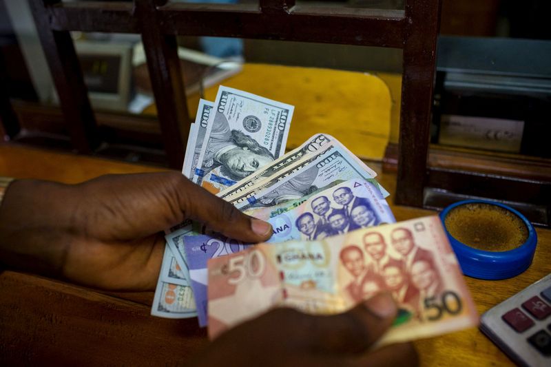 &copy; Reuters. FILE PHOTO: A man trades U.S. dollars for Ghanaian cedis at a currency exchange office in Accra, Ghana, June 15, 2015. Picture taken June 15. REUTERS/Francis Kokoroko/File Photo
