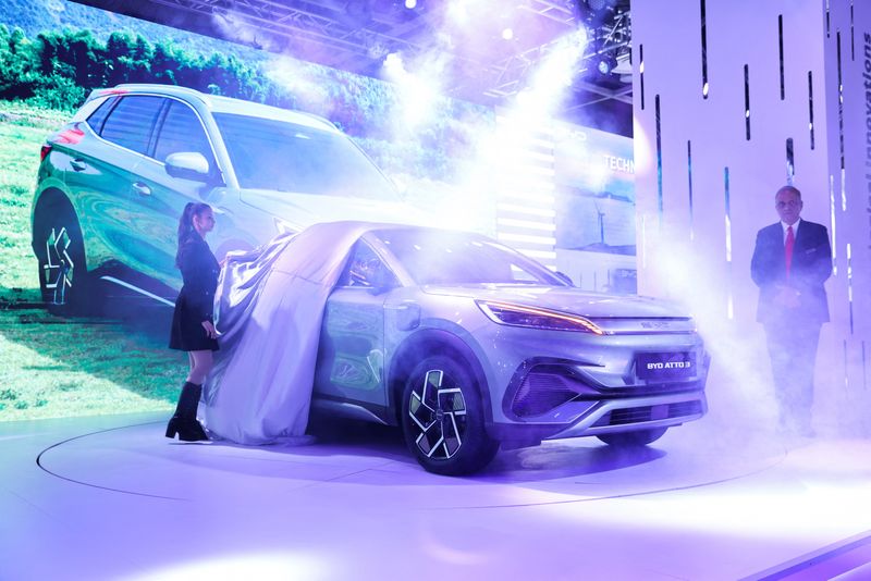 &copy; Reuters. Sanjay Gopalakrishnan, Senior Vice President of BYD India, looks on as a woman pulls a cover off the BYD Atto 3 electric SUV at the Auto Expo 2023 in Greater Noida, India, January 11, 2023. REUTERS/Anushree Fadnavis