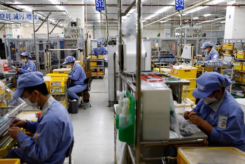&copy; Reuters. Funcionários usando máscaras trabalham em fábrica em Pequim
10/01/2023 REUTERS/Tingshu Wang