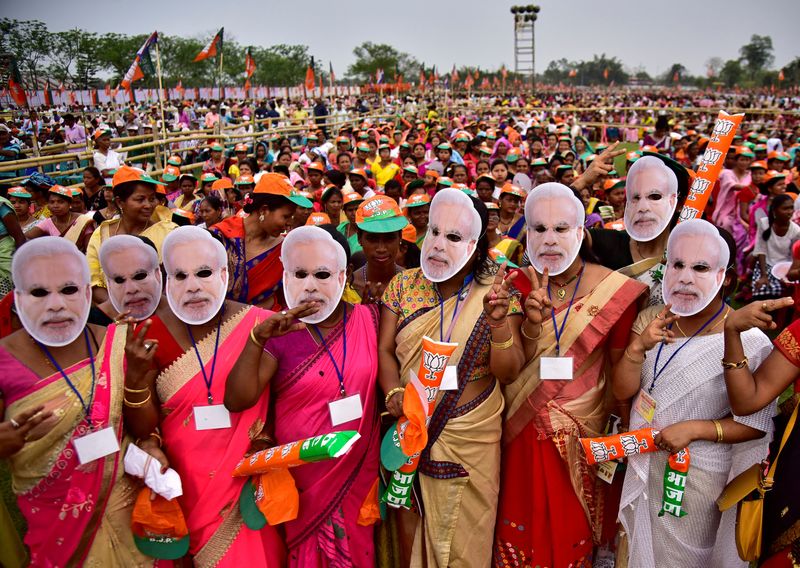 &copy; Reuters. FILE PHOTO: Supporter of India's ruling Bharatiya Janata Party (BJP) wearing masks of Prime Minister Narendra Modi attend an election campaign rally addressed by Modi at Moran town in the northeastern state of Assam, India, March 30, 2019. REUTERS/Anuwar 