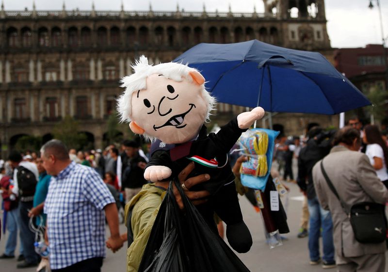 &copy; Reuters. FILE PHOTO: A street vendor displays a doll depicting Mexico's President Andres Manuel Lopez Obrador as people gather before Obrador's address of the nation on the first anniversary of his presidential election victory at Zocalo Square in Mexico City, Mex