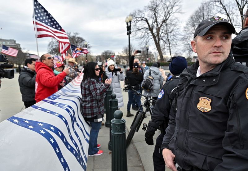 &copy; Reuters. FILE PHOTO: A U.S. Supreme Court police officer stands between flag waving supporters of those arrested in the January 6, 2021 attack on the U.S. Capitol and counter protestors to avoid conflict during a demonstration held between the U.S. Supreme Court a