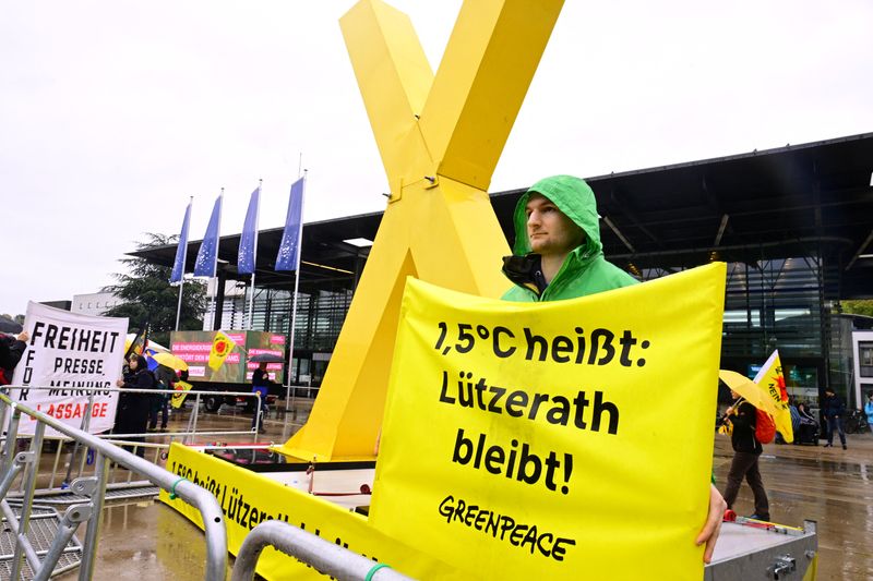 &copy; Reuters. Photo d'archives : Un manifestant tient une banderole pour protester contre le changement climatique et pour la préservation du village de Lutzerath, devant la Convention fédérale du parti des Verts d'Allemagne, à Bonn, en Allemagne.  /Photo prise le 