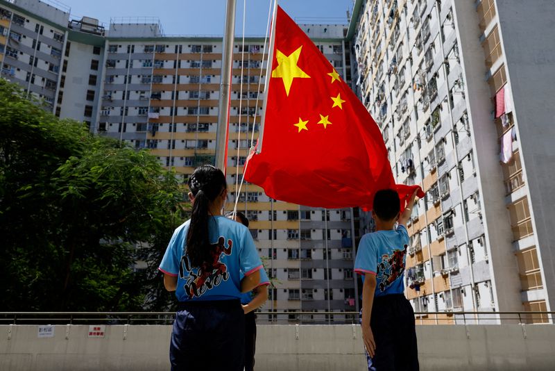 &copy; Reuters. FOTO DE ARCHIVO: Un equipo iza la bandera de una escuela primaria actúa tras la primera competición nacional de izado de bandera en Hong Kong, China, 4 de septiembre del 2022. REUTERS/Tyrone Siu