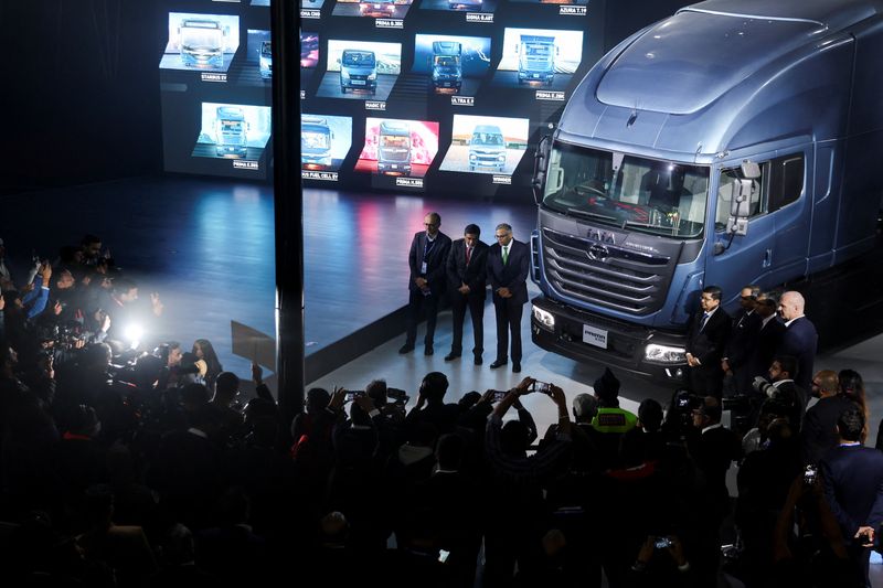 © Reuters. P. B. Balaji, CFO Tata Motors group, Girish Wagh, executive director of Tata Motors, and Natarajan Chandrasekaran, Chairman, Tata Motors, pose next to H.55S Hydrogen internal combustion engine truck unveiled at the Auto Expo 2023 in Greater Noida, India, January 11, 2023. REUTERS/Anushree Fadnavis