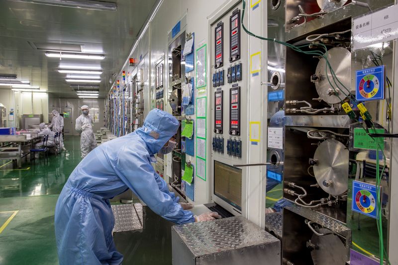 © Reuters. FILE PHOTO: Employees work at a production line manufacturing chips inside a factory of an electronics company in Chizhou, Anhui province, China March 21, 2018. REUTERS/Stringer  