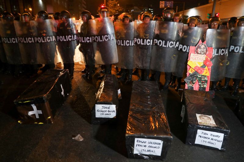 © Reuters. Security forces stand guard behind mockup coffins with the names of people who have died during previous protests as demonstrators demand the dissolution of Congress and democratic elections, in rejection of Dina Boluarte as Peru's president, after the ouster of leftist President Pedro Castillo, in Lima, Peru, January 12, 2023. REUTERS/Sebastian Castaneda